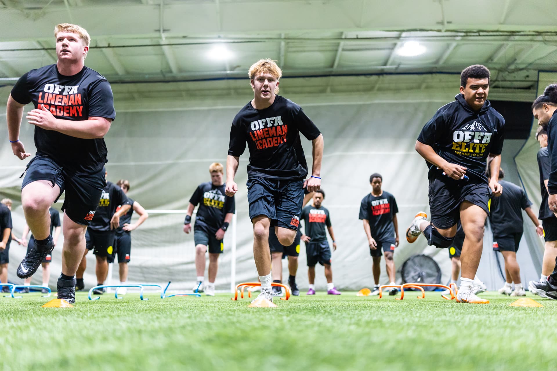 Offa linemen working through agility hurdles in full team gear